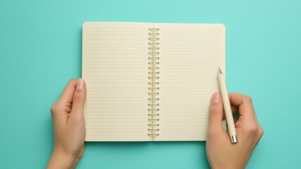 Open Spiral Notebook with Blank Pages Cream Pen Held by Hands on Aqua Background