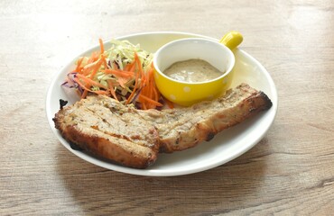 grilled Kurobuta chop pork steak with and salad dipping sauce on plate