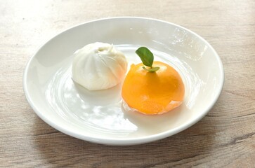 Chinese steamed bun stuffed sweet orange and salty chop pork on plate