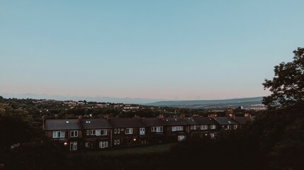 Suburban houses at dusk overlooking a valley.