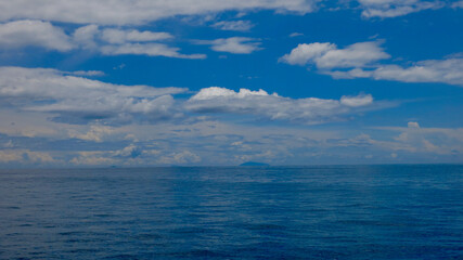 View of a calm ocean. Calm sea surface and clouds above the horizon.