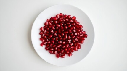 A minimalist plate of fresh pomegranate seeds, neatly arranged in a simple pattern on a plain white ceramic plate, Pomegranate seeds centered