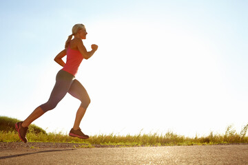Fitness, happy woman and running in nature space for cardio exercise, training and wellness. Below,...
