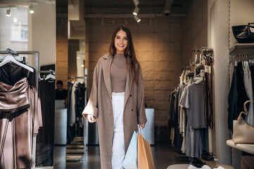 Happy facial expression. Woman chooses clothes in retail store