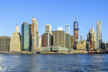 Fototapeta premium View from Pier 1 over the East River to the skyline of Manhattan, Dumbo, Downtown Brooklyn, Brooklyn, New York
