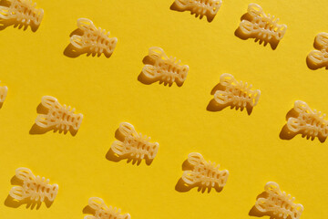 close up raw brushwood chips in the form of lobster on yellow background 