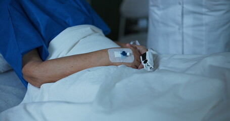 Close up shot doctor helps the elderly patient by fitting an oximeter onto her finger to monitor...