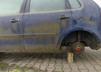 Abandoned Car Missing a Wheel on Blocks