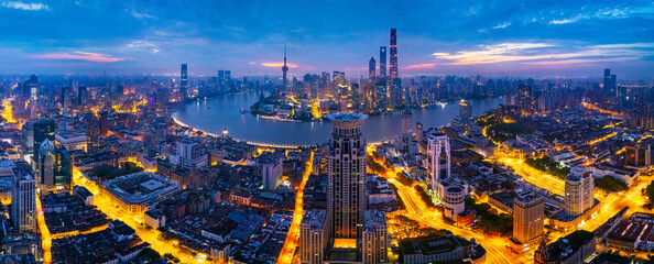 Aerial view of Shanghai skyline and bright city streets at dawn