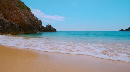 Fototapeta premium Serene Tropical Beach With Gentle Waves and Rocky Outcrops