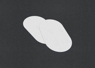 Two white ovals slightly overlapping on a gray background, minimalistic abstract design, Blank white Business card mockup stacks at grey textured paper background