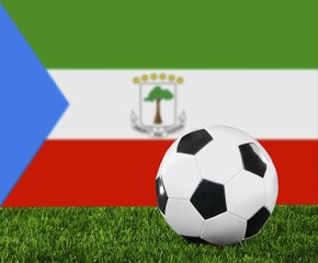 The Equatorial Guinea flag and soccer ball on the green grass