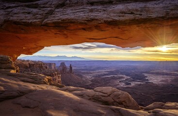 View through arch Mesa Arch at sunrise, Colorado River Canyon with the La Sal Mountains behind,...