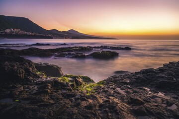 Rocky coast and sea at sunset, behind Bajamar and volcano Pico del Teide, Punta del Hidalgo, Tenerife, Canary Islands, Spain, Europe