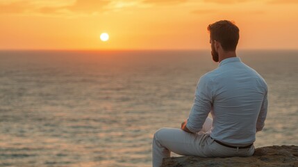 Mental health recovery and growth, A man sits on a rocky ledge, gazing at a vibrant sunset over the ocean, embodying tranquility and reflection.