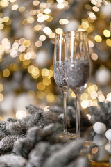 Two glasses standing on the table before the Christmas tree