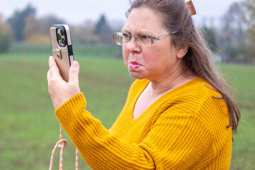 Angry Mature white woman yelling furiously on the phone, expressing frustration and emotional...