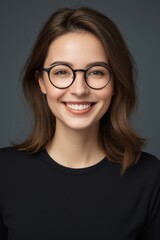 Fototapeta premium smiling woman with glasses and black shirt on dark background