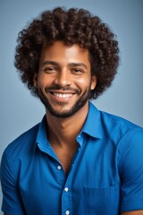 Obraz premium smiling man with afro hair and blue shirt posing for a picture