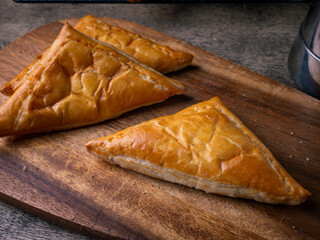 Fresh Baked puff pastry pie with filling on wooden cafe table