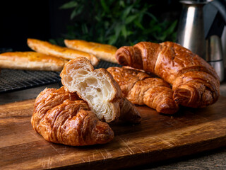 Fresh Baked French Croissants on wooden cafe table.