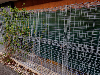 gabion wire basket, cages. fence in the front garden with a natural industrial look. made of...