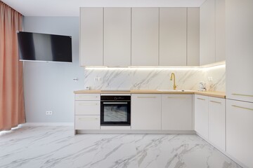 Kuchnia w nowoczesnym apartamencie w jasnych kolorach , biel,  i jasno brązowym blatem