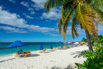 People and parasols in Shoal Bay beach, Caribbean dream landscape in Anguilla island, British West Indies  