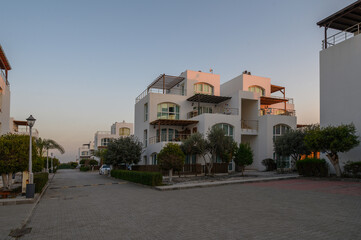 Sunset casts a warm glow on modern architecture in a coastal neighborhood