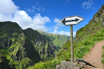 Road sign directing hikers in mountainous terrain