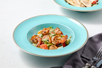 Minimalist Caesar Salad with Shrimp on Elegant Blue Plates in Soft Lighting