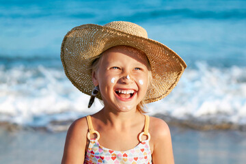 Sea Children Holiday. Sunscreen Sunblock Creme for Children. Happy Tanned Kid Girl with Sunscreen on Face Having Fun in Sea Background.