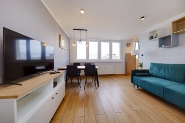 Salon w nowoczesnym apartamencie z ciemnozieloną pluszową sofą © arteffect.pl