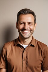 Obraz premium smiling man in brown shirt standing against a wall with a white background