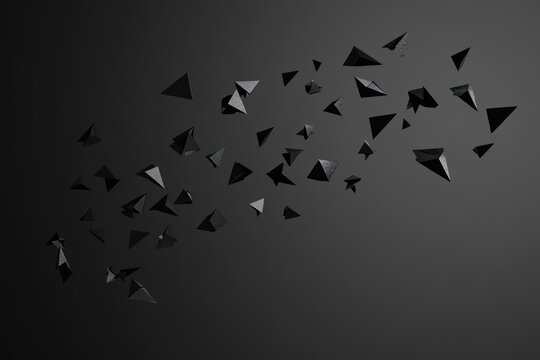 Abstract dark grey background with scattered 3D triangular shapes.