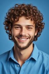 Fototapeta premium smiling man with curly hair and beard wearing blue shirt