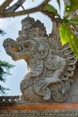 Traditional house decorations in Bali, Indonesia. Traditional statues and sculptures of demons and gods with beautiful colorful plants and flowers. 