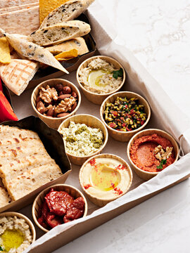 A vibrant assortment of Mediterranean dips, including hummus and baba ganoush, served with freshly baked artisan bread and crispy crackers. Ideal for sharing with friends