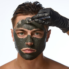 Man with smooth skin looking directly forward, and hand wearing black glove holding brush, mask...