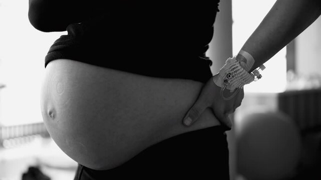 Monochrome close-up of very pregnant belly before childbirth at clinic in black and white