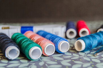 Reels of different coloured thread  on a green floral baackground