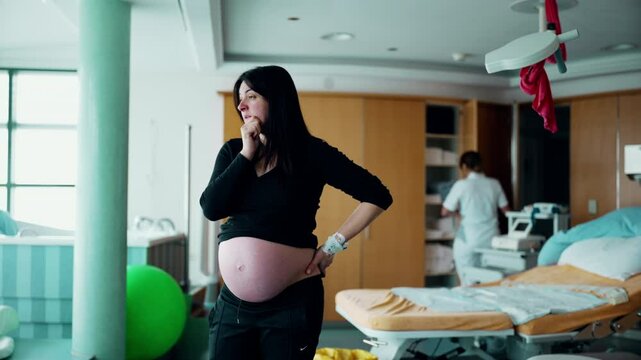 Preoccupied pregnant woman standing at hospital clinic during prelabor contractions about to give birth to baby. Real life worried 30s person, equipment in background