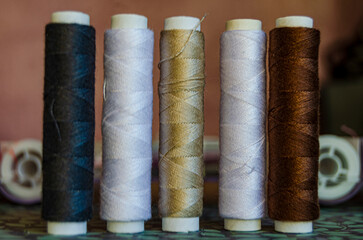 Reels of different coloured thread  on a green floral baackground