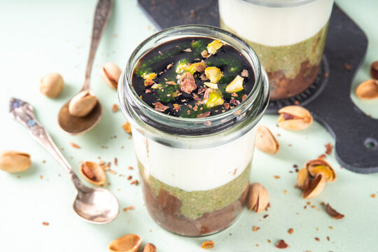 Dubai chocolate dessert cup, layered pistachio kadaif parfait cake with chocolate, dubai chocolate cream, whipped cream, crushed pistachio nuts, copy space