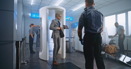 Airport Terminal Checkpoint: Diverse People Walking Through Metal Detector Gates, Taking Luggage...