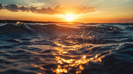 Obraz premium Golden sunset over a calm ocean. Waves gently lap the shore.