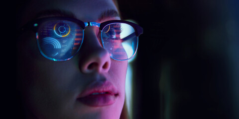 Close-up of woman wearing glasses reflecting bar charts and financial analytics, symbolizing...