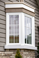 Fototapeta premium Elegant Bay Window with White Frame and Brick Exterior. Modern Home Design and Real Estate Photography