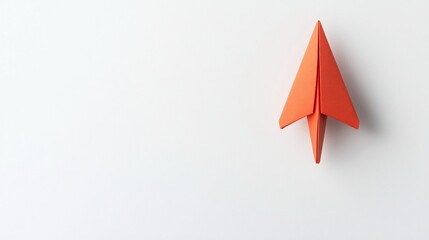 Orange Paper Airplane on White Background: A Symbol of Dreams and Aspirations