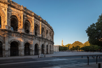 Ancient Roman amphitheatre and Church of Sainte Perpetue in Nimes at sunset, Occitanie region of southern France